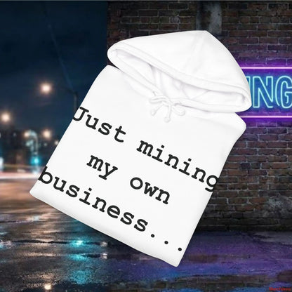 White hoodie with text 'Just mining my own business...' against a nighttime city street background.