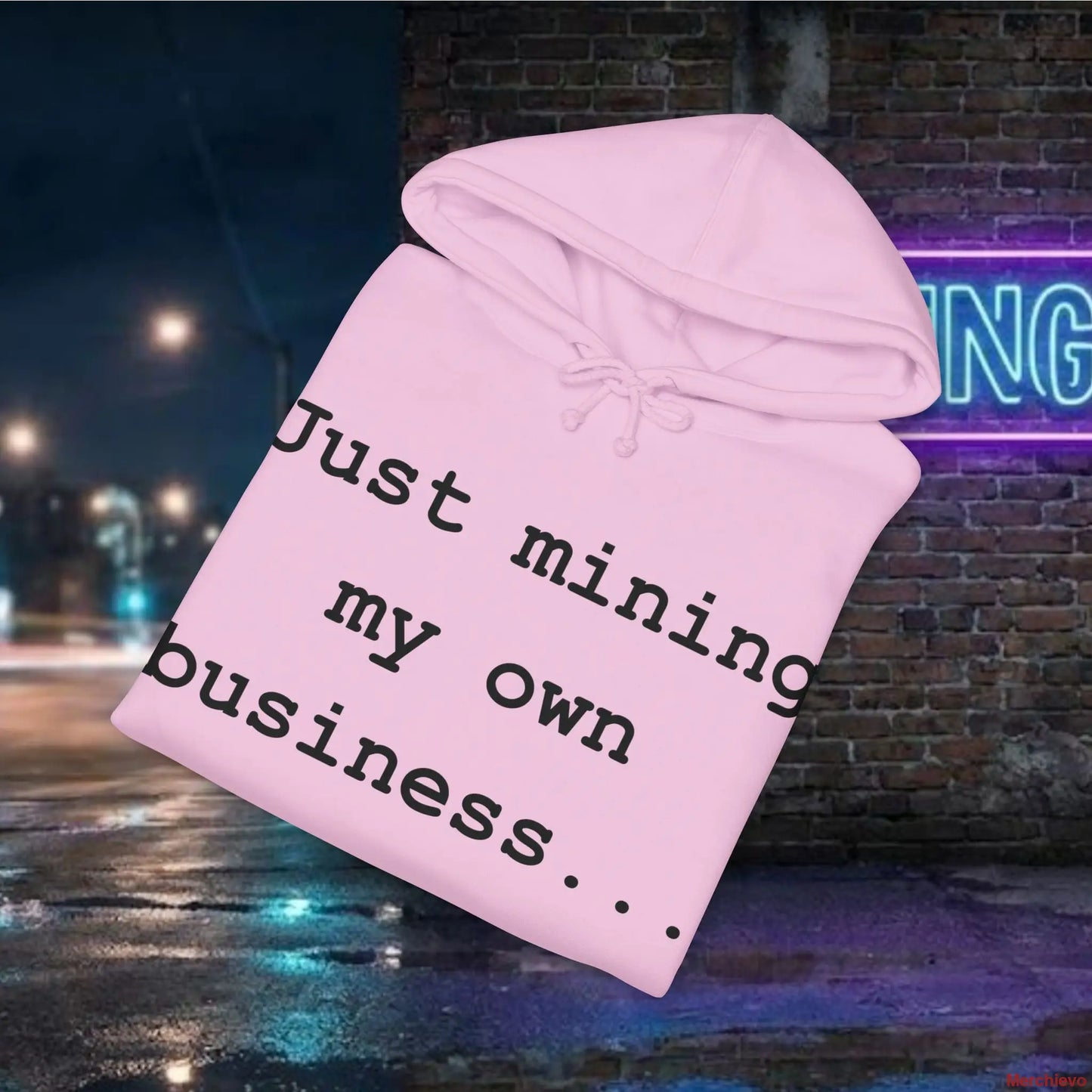 Pink hoodie with text 'Just mining my own business' against a nighttime city street background.