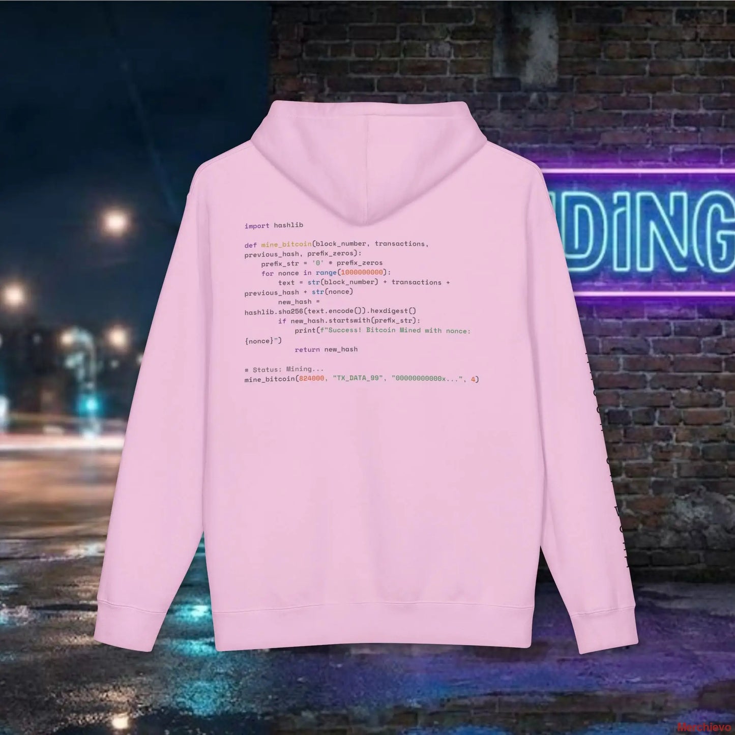 Pink hoodie with code design on the back against a neon sign and street background